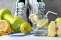 Sneakers, dumbbell, glass of water with lemon, measuring tape, jump rope, lime, green Apple, on a gray background