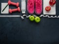 Sneakers dumbbells bottle of water apple and measure tape Royalty Free Stock Photo