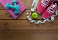 Sneakers dumbbells bottle of water apple and measure tape Royalty Free Stock Photo