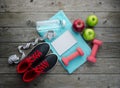 Sneakers dumbbells notebook bottle of water apple and measure tape Royalty Free Stock Photo