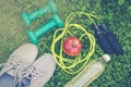 Sneakers, dumbbells, water on fresh green grass. Royalty Free Stock Photo