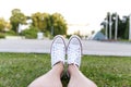 Sneakers on green grass in city park