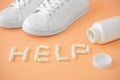 Sneakers and pills. Supportive drugs for the activities. Chondroitin capsules and sneakers. Word help is lined with capsules or Royalty Free Stock Photo