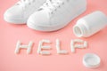 Sneakers and pills. Supportive drugs for the activities. Chondroitin capsules and training shoes. Word help is lined with capsules Royalty Free Stock Photo