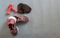 Sneakers ready to training at home, making exercise in a fitness class with muscular equipment. Jumping rope, pink dumbbells and