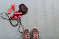 Sneakers ready to training at home, making exercise in a fitness class with muscular equipment. Jumping rope, pink dumbbells and