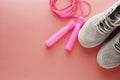 Sneakers, sport shoes and jumping rope over pink background. Health, running workout, fitness and yoga concept. Feminine Royalty Free Stock Photo