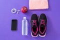 Sneakers, water bottle, towel, mobile phone with headphones and apple Royalty Free Stock Photo