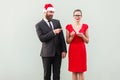 Sneer and mock concept. Man pointing fingers at woman and smiling. Woman crying and holding bad gift