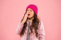 Sneezing. Cold climate weather. Little girl sick ill pink background. Kid puffer jacket and knitted hat. Winter cold flu