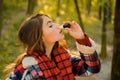 Sneezing young girl with nose wiper among yellow trees in park. Young woman blowing nose at nature. Woman makes a cure Royalty Free Stock Photo