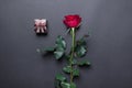 Sngle red rose and brown jewelery box on black colored paper background Royalty Free Stock Photo