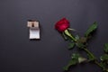 sngle red rose and open brown jewelery box on black colored paper background  with copy space Royalty Free Stock Photo