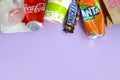 Snickers chocolate bar wrapping lies with empty red Coca Cola and orange Fanta tin cans next to mcdonalds paper bags and cups on