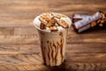 Snickers milkshake served in glass side view on wooden table morning meal