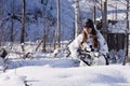 Sniper girl in white camouflage at winter forest. Royalty Free Stock Photo