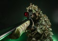 Sniper in a poncho camouflage suit and a sniper rifle