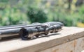 Sniper rifle lies on a wooden background. Optical sight close-up