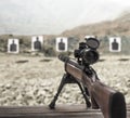 Sniper rifle on wooden table at shooting range Royalty Free Stock Photo