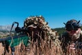 Sniper soldier assisted by an assistant to observe the area to be targeted with modern warfare tactical virtual reality