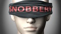 Snobbery can make things harder to see or makes us blind to the reality - pictured as word Snobbery on a blindfold to symbolize