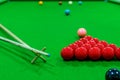 The snooker balls on the table consisted of red, black, pink, blue, green, white, brown, and yellow, with a cue placed on wood on Royalty Free Stock Photo