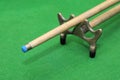 Snooker cue with rest on green background Royalty Free Stock Photo