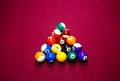 Snooker multicolored balls lay as a pyramid on the table. Closeup view. Billiard red table with cue and balls. Leisure, hobby, Royalty Free Stock Photo