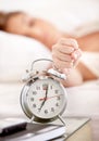 Snooze, alarm and hand of woman in morning wake up with tired, exhausted and no sleep at home. Depression, sleeping and Royalty Free Stock Photo