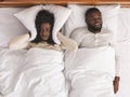 Woman covering ears with pillow, can not handle snoring husband