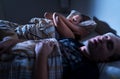 Snoring at night. Sleep apnea. Frustrated annoyed sleepless woman covering ears with pillow in bed. Wife staying awake. Royalty Free Stock Photo