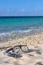 Snorkel and mask on the beach sand on the sea/sky background, sh