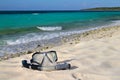 Snorkel and mask on the beach sand on the sea/sky background