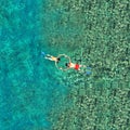 Snorkeling couple in the sea water. View from a drone