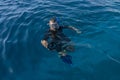 Snorkeling diver photographer with camera in sea water Royalty Free Stock Photo