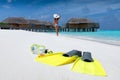 Snorkeling gear on a tropical beach with woman walking on the beach