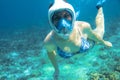 Snorkeling girl in bikini and full-face snorkeling mask in coral reef. Snorkel in coral reef of tropical sea. Royalty Free Stock Photo