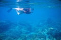 Snorkeling girl in full-face snorkeling mask and fins. Woman swimming. Royalty Free Stock Photo