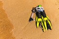 Snorkeling mask with flippers on a sandy beach. Yellow flippers on the shore. Beach vacation, snorkeling equipment on Royalty Free Stock Photo