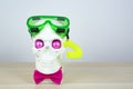 Snorkeling scuba diving skull sculpture with pink eyes with mask a yellow tube and a pink bow tie. parody of a scuba diver