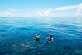 Snorkeling tourists on turquoise water of Indian Ocean