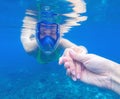 Snorkeling woman in full-face snorkeling mask. Swimming girl holds hand of partner Royalty Free Stock Photo