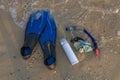 Snorkelling equipment and thermo water bottle on sand on sea beach. Scuba diving set, flippers, mask, snorkel on sand Royalty Free Stock Photo