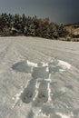 Snow angel in the fresh snow. Trace from the human adult body in winter landscape.Print of body copy space.Crime scene in nature,