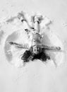 Snow angel made by a kid in the snow. Child girl playing and making a snow angel in the snow. Royalty Free Stock Photo