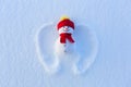 Snow angel with wings in red hat and scarf is laying on the snow. Fabulous winter background for a leaflet.