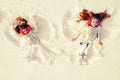 Snow angels made by a kids in the snow. Smiling children lying on snow with copy space. Funny kids making snow angel Royalty Free Stock Photo