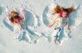 Snow angels made by a kids in the snow. Smiling children lying on snow with copy space. Funny kids making snow angel Royalty Free Stock Photo