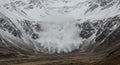 Snow Avalanche Erupts in Desolate Mountain Valley A powerful snow avalanche thunders down a steep mountainside symbolizing Royalty Free Stock Photo