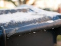 Snow on the bin. gray trash can in a row with snow on top on a cold winter day. Snow Thaw. Thaw Royalty Free Stock Photo